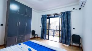 a bedroom with a bed and a large window at K&K Luxurious Landing in Limbe