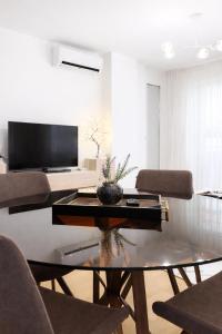 a living room with a glass table and chairs at Avenoir Suite in Banja Luka