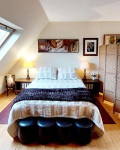 a large bed in a room with two lamps at Ti Ar Skol, chambre d'hôtes in Huelgoat