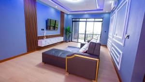 a living room with a couch and a tv at K&K Luxurious Landing in Limbe
