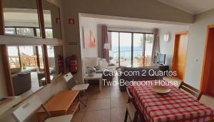 a room with a bed and a table with a view of the ocean at First Balcony - Porto Santo in Porto Santo