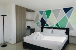 a bedroom with a white bed with a colorful wall at Aparthotel Dalmacija in Privlaka +51 photos