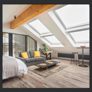 a bedroom with skylights and a couch and a table at Uno St Ives - Boutique Luxury Accommodation in St Ives