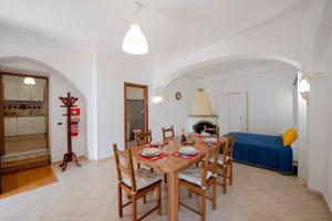 a dining room with a table and a blue couch at Oasi Milano in Furore