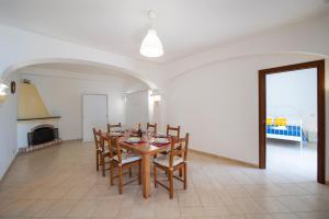a dining room with a wooden table and chairs at Oasi Milano in Furore +27 photos