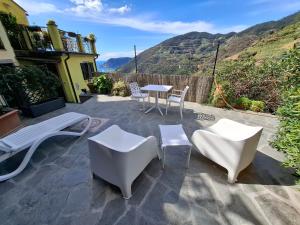 a patio with white chairs and tables with a view at Il vigneto in Vernazza