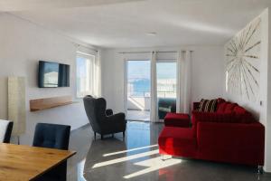 a living room with a red couch and chairs at Aparthotel Dalmacija in Privlaka