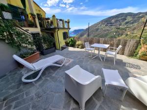 a patio with white chairs and tables and a view at Il vigneto in Vernazza