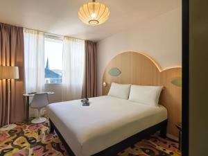 a hotel room with a large bed and a window at ibis Styles Metz Centre in Metz +20 photos