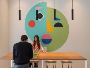 a man and woman standing at a table in front of a painting at ibis Styles Metz Centre in Metz