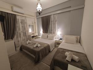 een hotelkamer met twee bedden en een kroonluchter bij Hotel Galaxidi in Galaxidhion