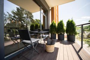 a balcony with chairs and a table and potted plants at SkyGarden Studio - Private Terrace and View in Quiet Jūrmala in Jūrmala