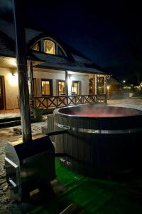 a house at night with a round pool in the yard at Casa Strabunicului in Pîrteştii de Sus