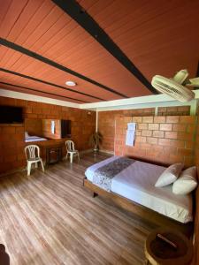 a bedroom with a bed and a brick wall at Finca Hotel Villa Nieves in Tuluá