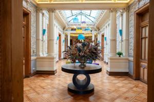 a hallway with a table with a vase of flowers at Happy House Hostel in Santiago +150 photos