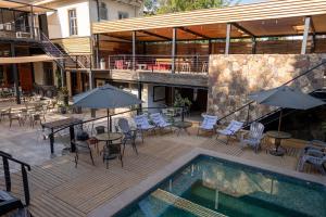 an outdoor patio with tables and chairs and a pool at Happy House Hostel in Santiago