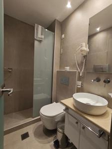 een badkamer met een toilet, een wastafel en een douche bij Hotel Galaxidi in Galaxidhion