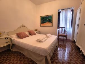 a bedroom with a bed with a chair and a window at Casa ALFANG in Torrent