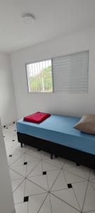 a bedroom with a blue bed in a room with a window at Itu Loft Pousada Girassol in Itu