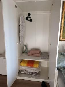 a white closet with towels and towels at Stan na dan Valjevo Centar in Valjevo +16 photos