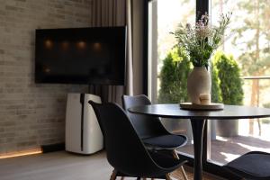 a dining room with a table and chairs and a television at SkyGarden Studio - Private Terrace and View in Quiet Jūrmala in Jūrmala +30 photos