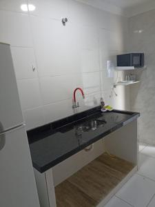 a kitchen counter with a sink in a room at Itu Loft Pousada Girassol in Itu