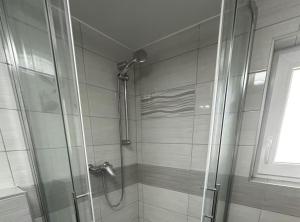 a shower with a glass door in a bathroom at Sošice Garden Apartments in Sošice +14 photos