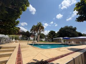 a pool with a palm tree next to a building at Brisas de melgar in Melgar