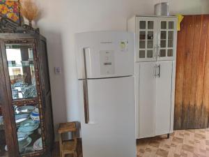 a kitchen with a refrigerator and a cabinet with dishes at Belvedere das Estrelas in Lençóis