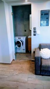 a living room with a washing machine and a couch at Jasmine Apartments in Lefkada