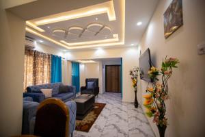 a living room with a blue couch and chairs at Winners Home in Kumasi