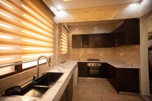 a large kitchen with a sink and a stove at Winners Home in Kumasi