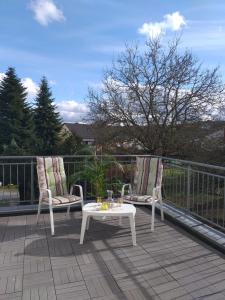 two chairs and a coffee table on a balcony at Apartment Zwei Schlafzimmer und absperrbare Fahrradgarage in Baumholder
