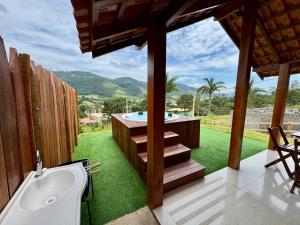 a bathroom with a bath tub and a view of a yard at Chalés São Pedro in Socorro