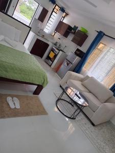 a living room with a couch and a bed at Diani Beach Studio with Pool, Beach Access in Diani Beach