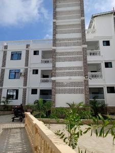 a tall white building with a stair tower at Diani Beach Studio with Pool, Beach Access in Diani Beach