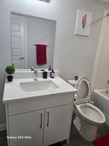 a bathroom with a white sink and a toilet at Omos Home in Saskatoon