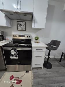 a kitchen with a stove and a white counter at Omos Home in Saskatoon +32 photos