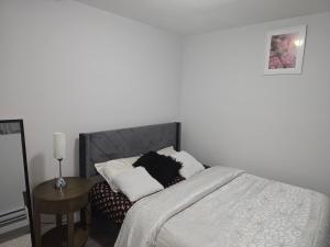 a bedroom with a bed and a side table at Omos Home in Saskatoon