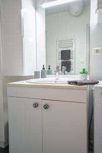 a white bathroom with a sink and a mirror at L'escale in Angers