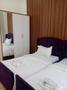 two beds in a hotel room with a mirror at Dar Alslam hostel in Nizwa