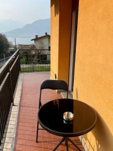 a black table and a chair on a balcony at Casa Fiocco vista Lago in Pisogne
