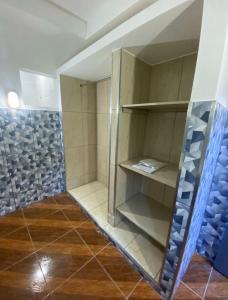 a walk in shower with blue and white tiles at Microcasas in Nova Friburgo