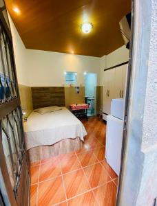 a small bedroom with a bed and a red table at Microcasas in Nova Friburgo