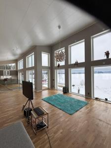 a living room with a green rug and windows at Lake View Villa in Falun