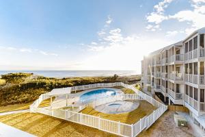 an apartment building with a swimming pool and the ocean at ABDV22 Dunescape Villas 236 in Atlantic Beach
