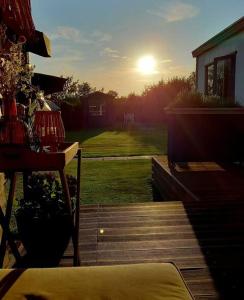 Blick von einer Terrasse auf den Sonnenuntergang in der Unterkunft De Hooglander in Westergeest