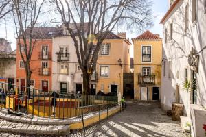 a person walking down a street next to buildings at Alfama Tiny by Homing in Lisbon