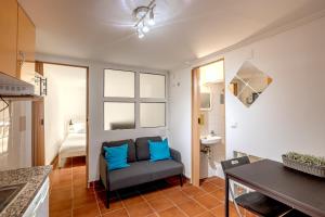 a living room with a blue couch and a sink at Alfama Tiny by Homing in Lisbon