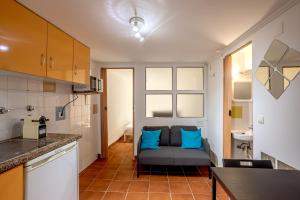 a kitchen with a couch with blue pillows in it at Alfama Tiny by Homing in Lisbon +12 photos